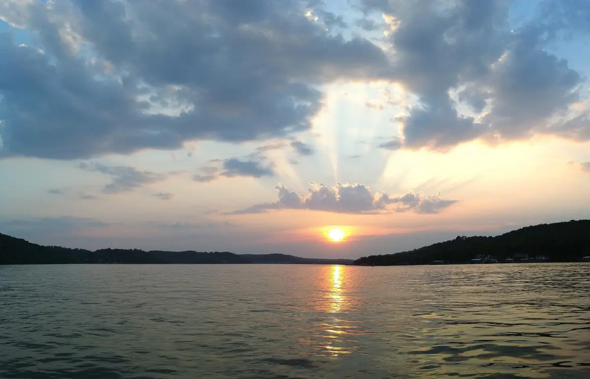 Sonnenstrahlen brechen durch Wolken über dem ruhigen Wasser des Lake of the Ozarks