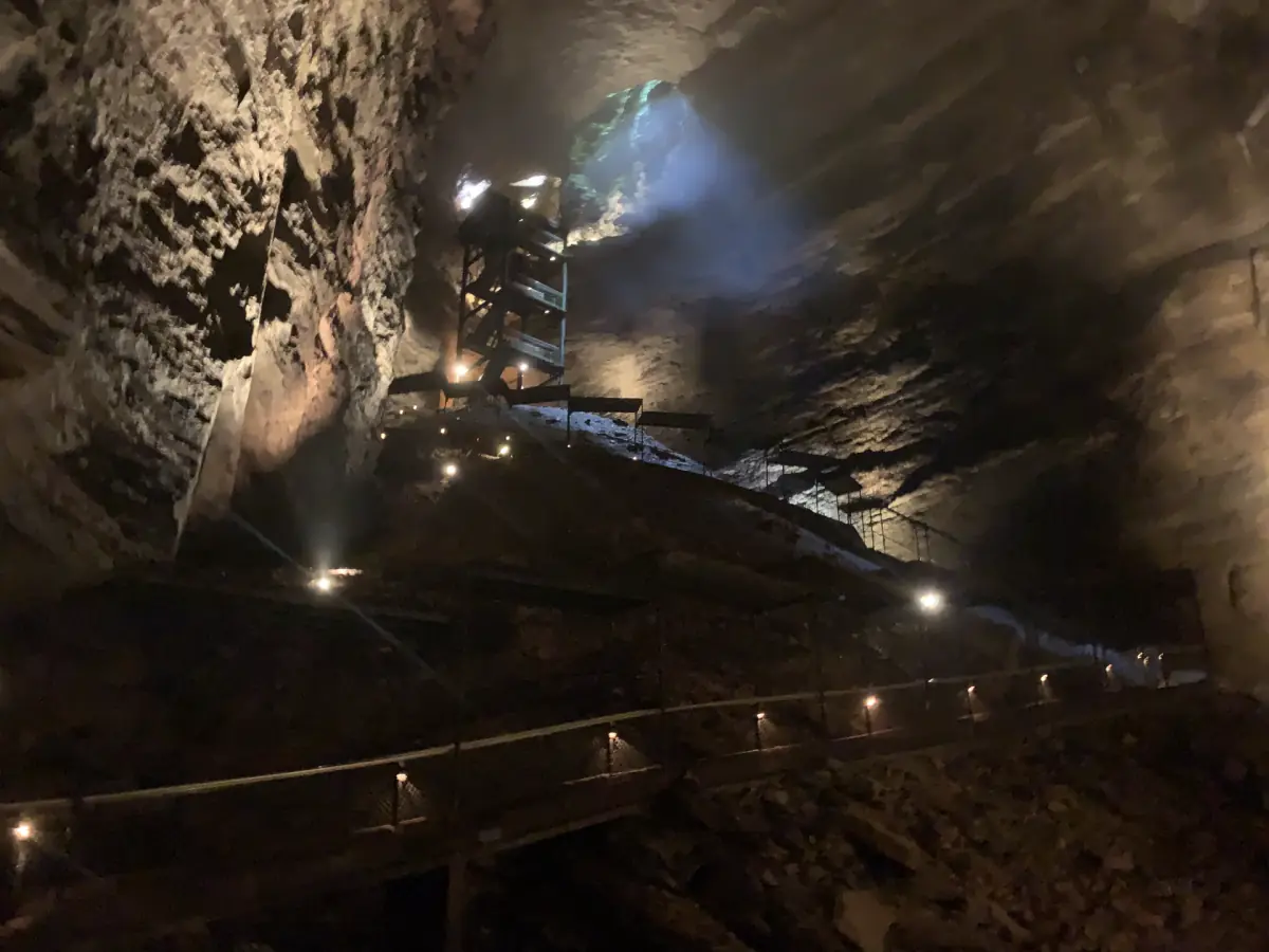 Large cave passage with lamps along the path and rough rock walls at Marvel Cave