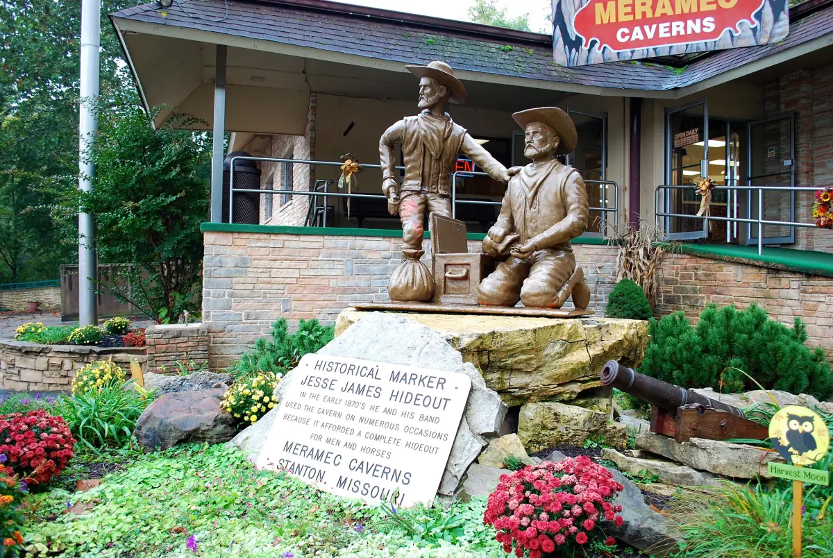 Bronze statue of two figures and a Jesse James hideout marker at Meramec Caverns