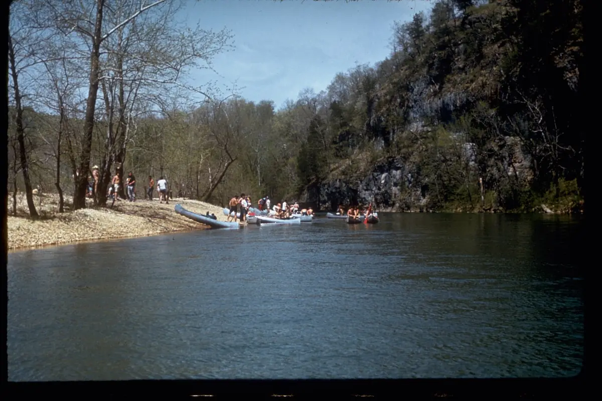 Clear Ozark river with a gravel bar and a rocky bluff in spring
