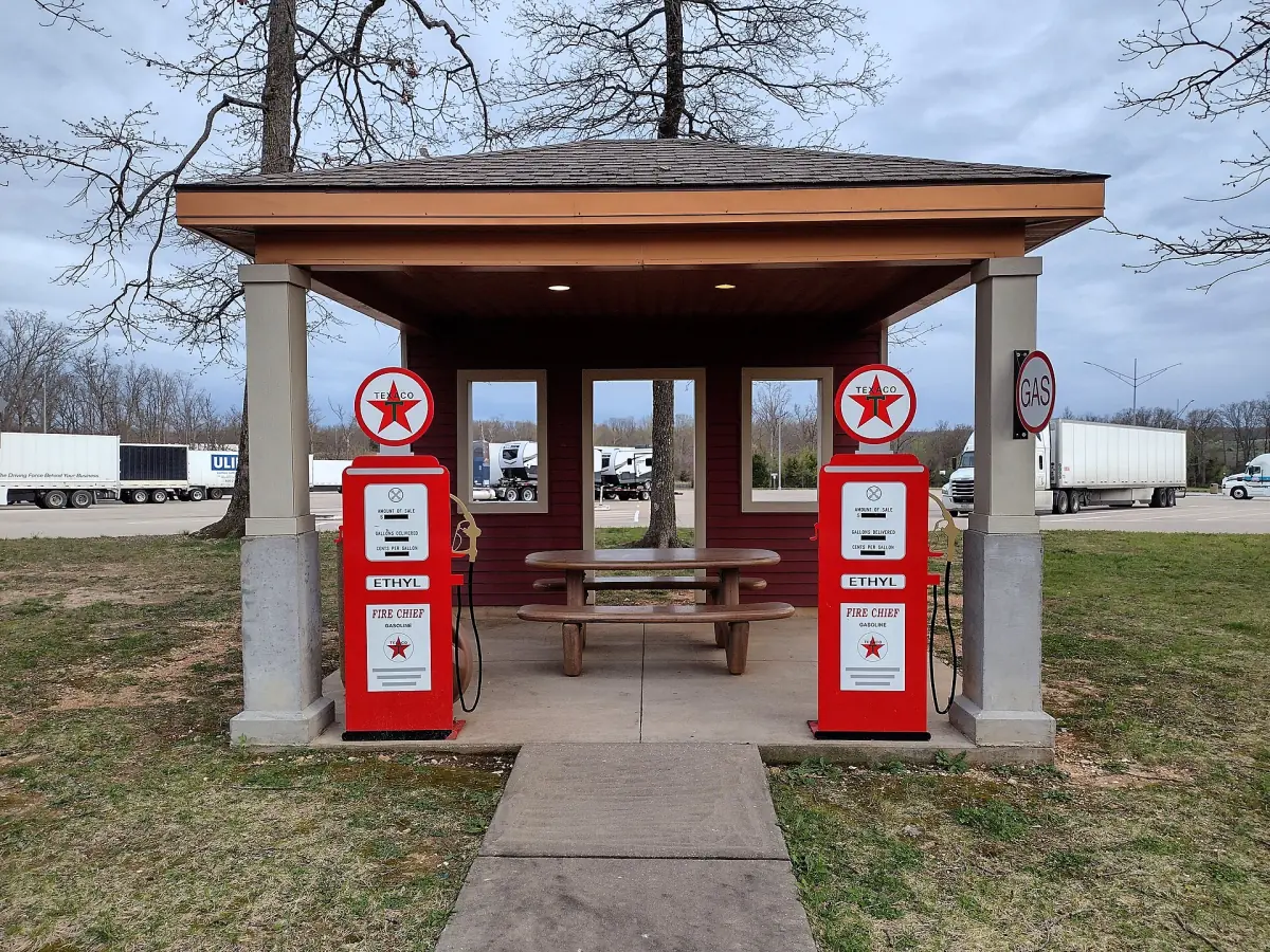 Red vintage Texaco gas pumps in a covered picnic shelter at a Route 66 rest area