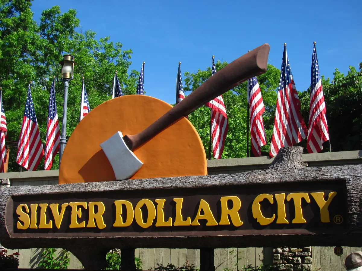 Silver Dollar City entrance sign with an axe and a row of American flags